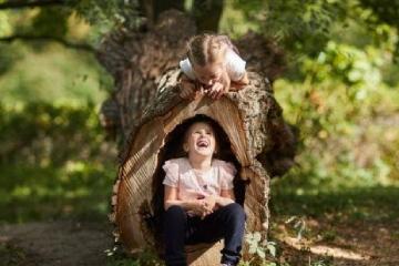 Blog, dziewczynka siedząca w pniu drzewa